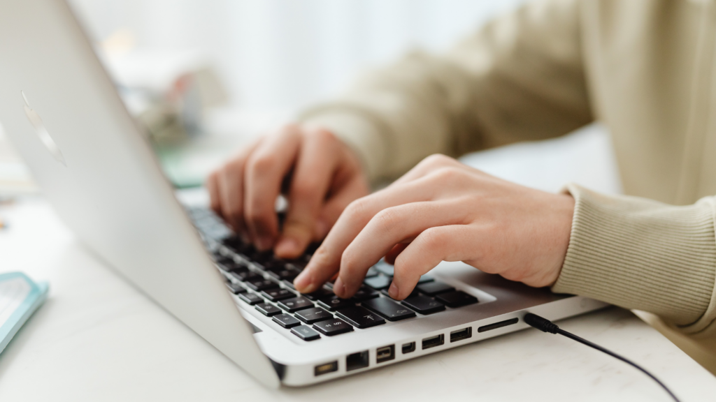 Business owner typing responses to customer reviews on laptop