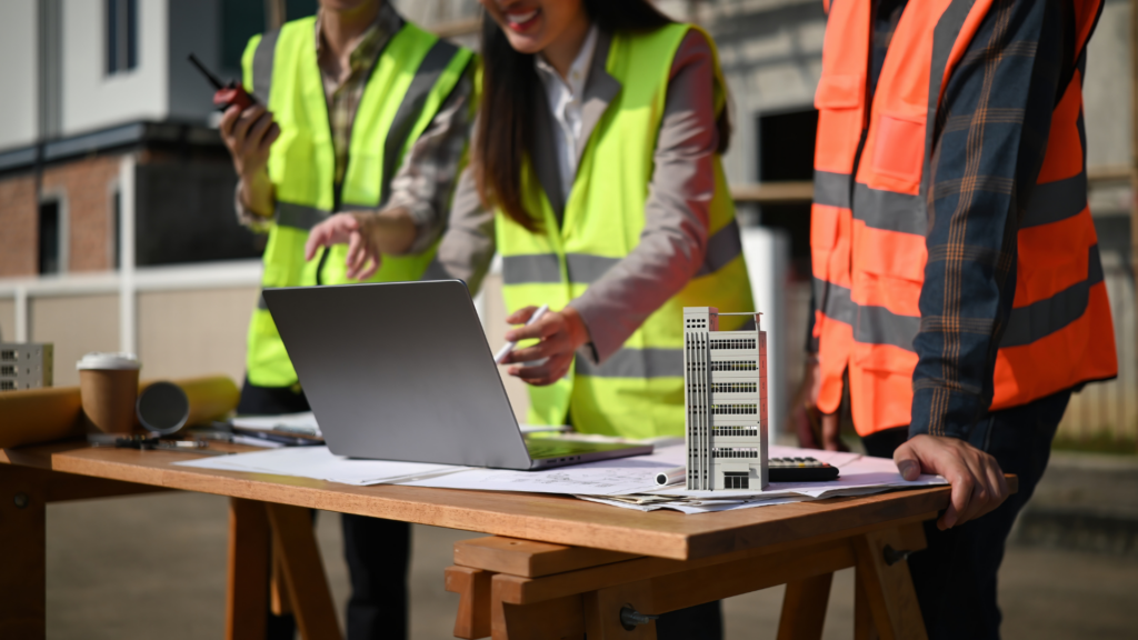 Construction team reviewing digital content strategy on laptop at jobsite