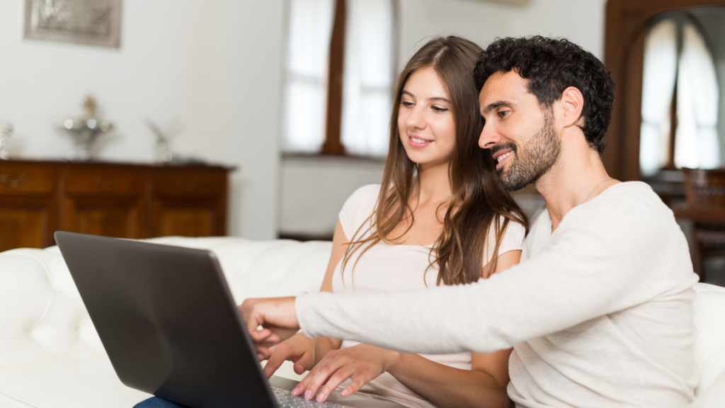 Couple searching for restaurants together on a laptop at home