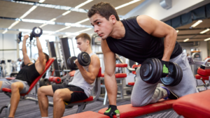 Group of local gym members strength training together in class
