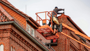 Roofing technician performing repairs using an aerial work platform