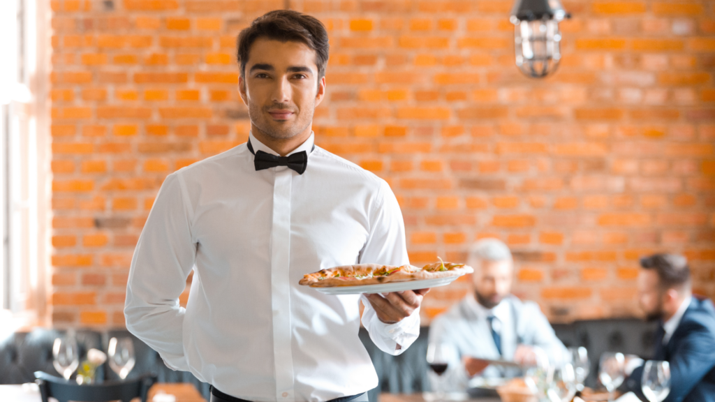 Waiter presenting a pizza inside a modern restaurant dining room