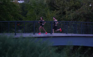 two people running over a bridge