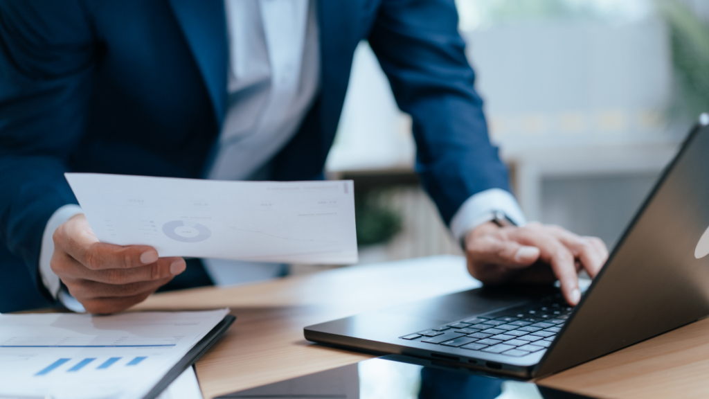 Businessman comparing printed data with laptop for accuracy checks