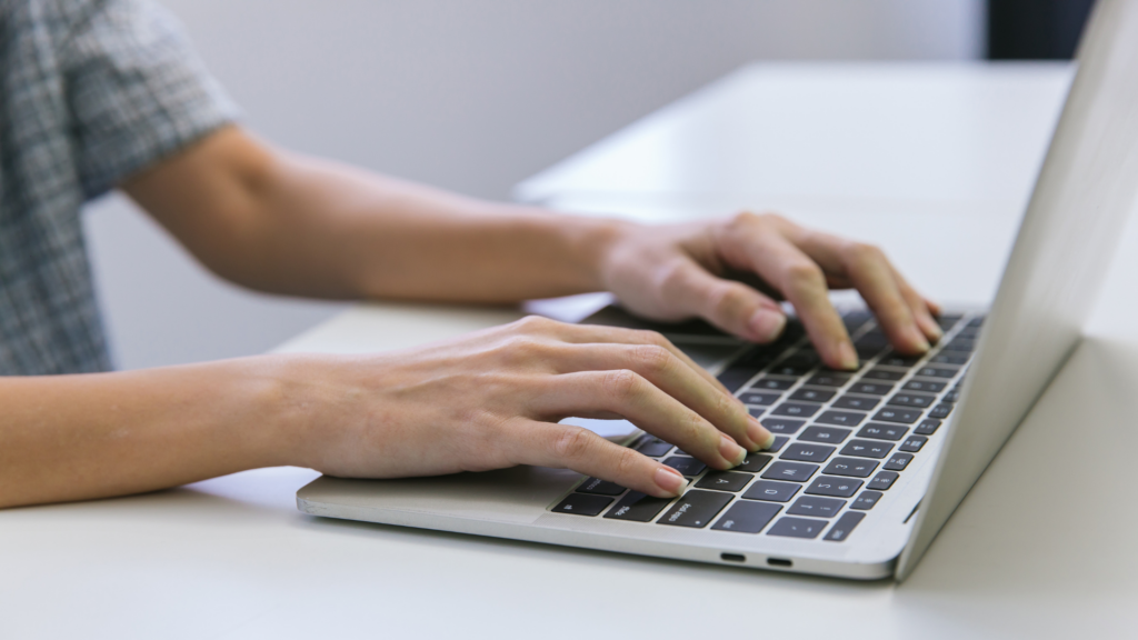 Close up of hands typing while researching keywords online