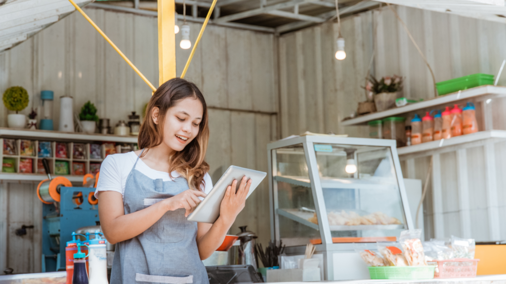 Food stall owner checking her business listing on a tablet