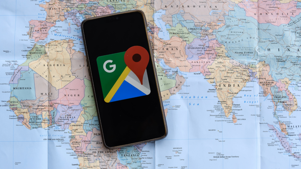Google Maps icon displayed on phone over world map