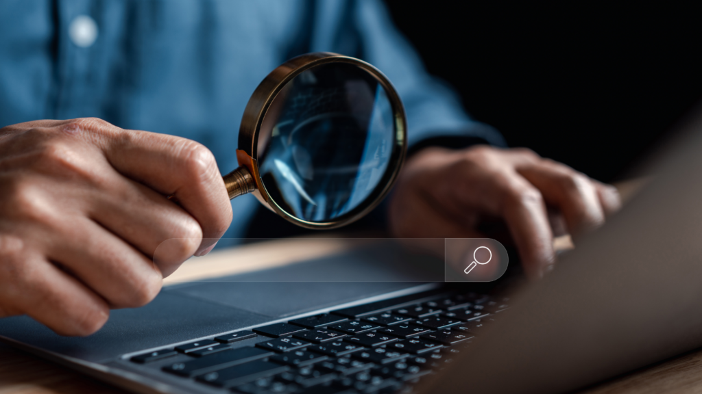 Magnifying glass reviewing search data on a laptop screen