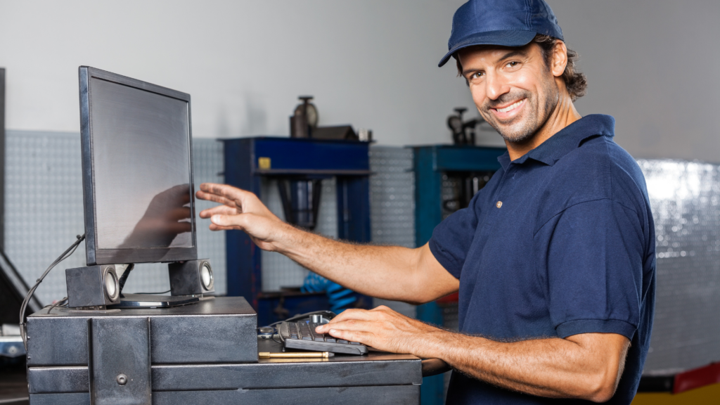 Mechanic managing customer reviews on shop office computer