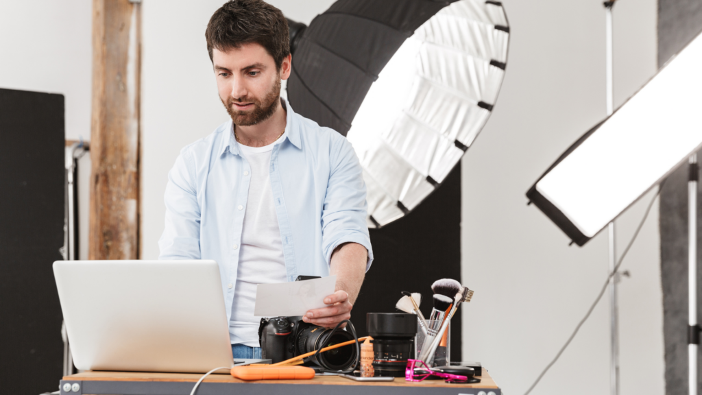 Studio photographer reviewing site performance alongside camera gear
