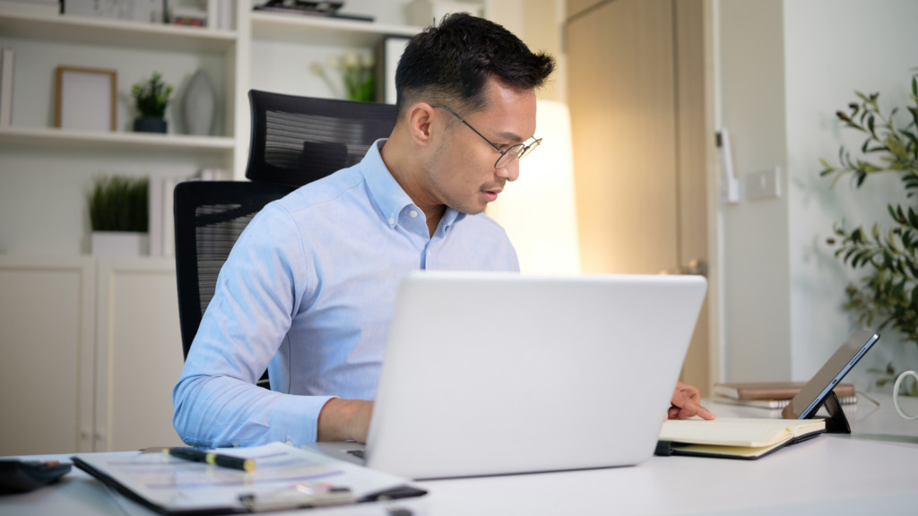 Business owner checking and updating business information at a desk with laptop