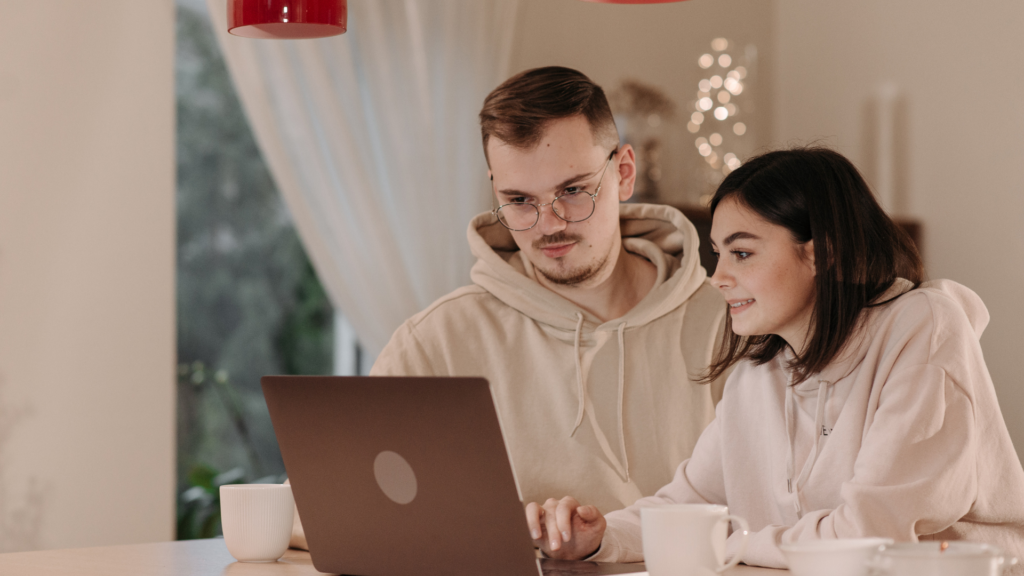 Couple searching for rental homes online on a laptop
