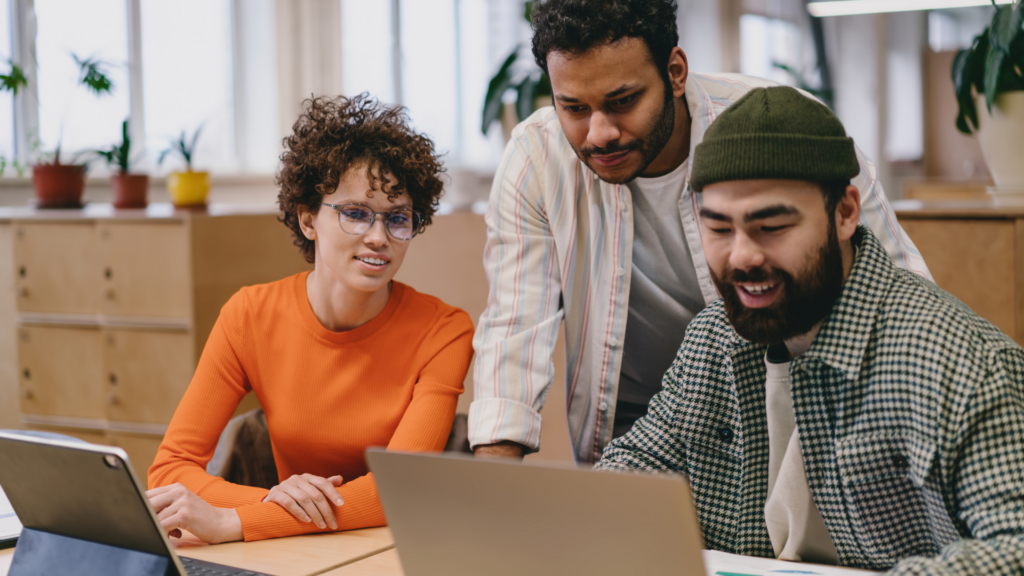 Coworkers discussing a local content strategy while looking at a laptop screen