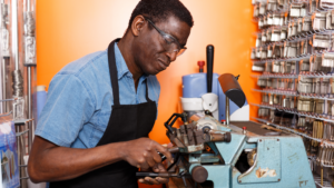 Experienced locksmith working at a key cutting machine in a shop