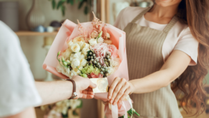 Local florist serving a customer with a fresh pastel flower bouquet