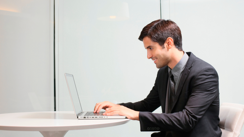 Professional reviewing performance reports on a laptop at a modern desk