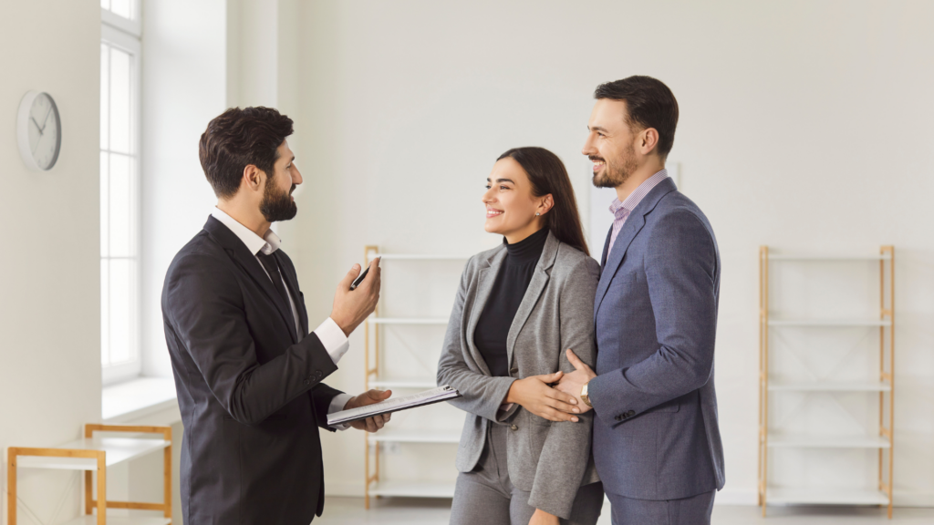 Property manager reviewing leasing details with a couple in an empty apartment
