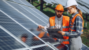 Solar professionals in safety gear checking panels and project documents